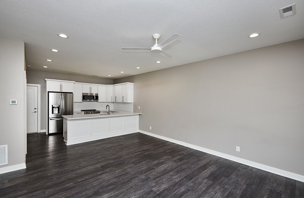 A spacious kitchen with a fan on the ceiling.