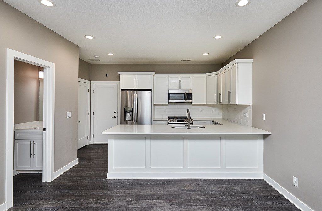 A kitchen with white cabinets and a large island.