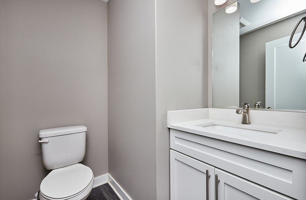 A white toilet sits next to a white sink in a bathroom.