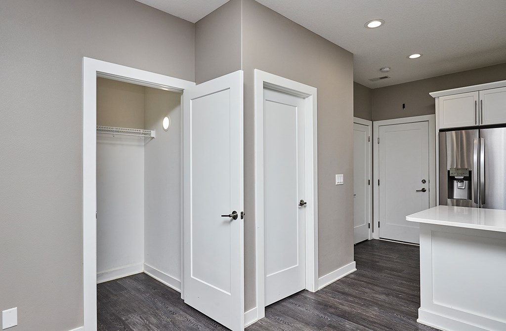 A kitchen with white cabinets and a grey floor.