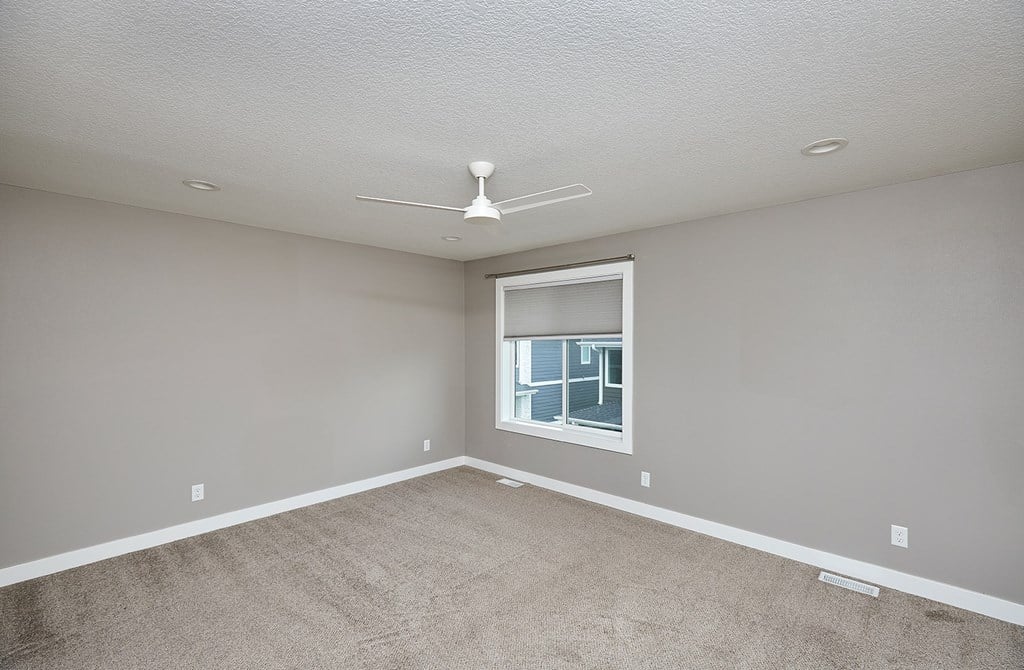 A room with a window and a ceiling fan.