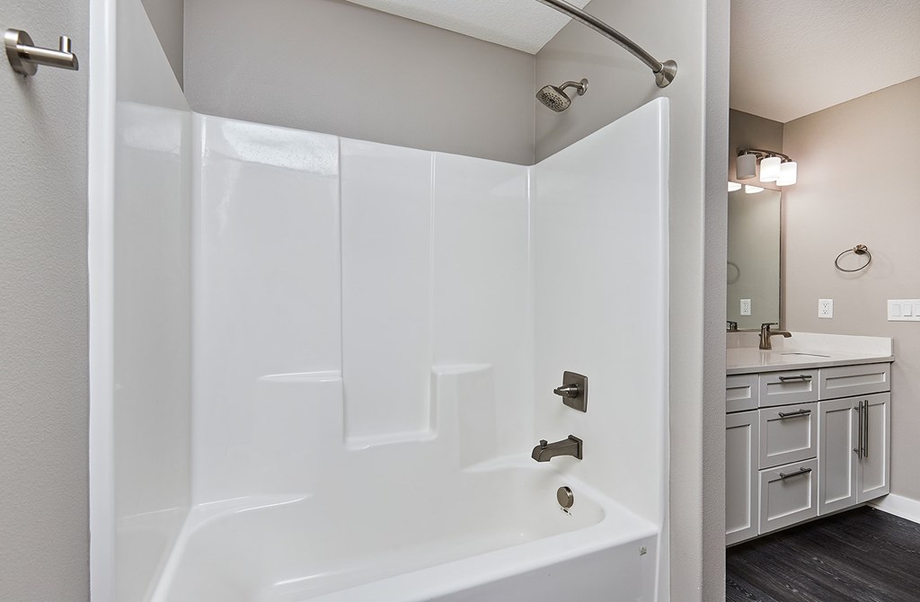 A white bathroom with a walk in shower and a sink.