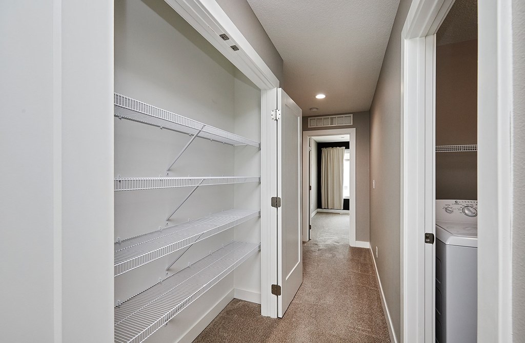 A long hallway with a laundry machine at the end.