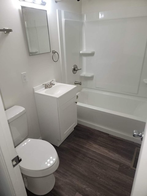 A white toilet sits next to a sink in a small bathroom.