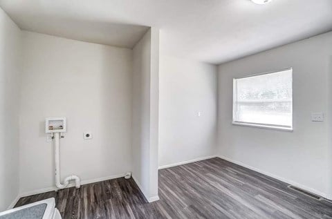 A room with a window and a white pipe on the wall.