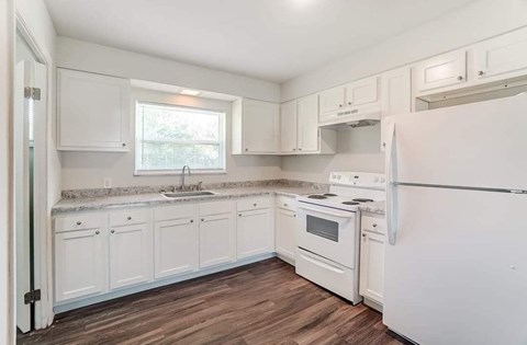 A kitchen with white cabinets and appliances.
