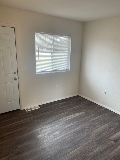 A room with a white door and a window with blinds.