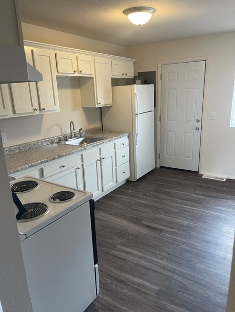 A kitchen with white appliances and cabinets.