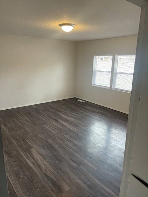 A room with a wooden floor and a window.