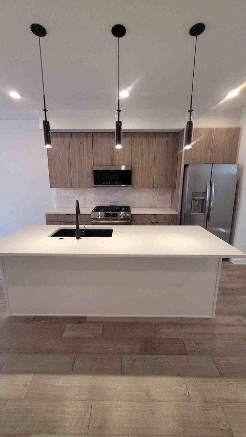 A modern kitchen with a white countertop and a black stove.