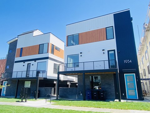 A modern two story building with a balcony on the first floor.