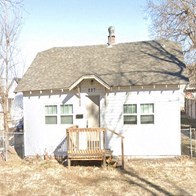 a white house with a wooden bench in front of it