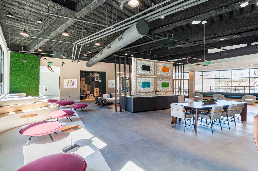 A modern open plan office space with a green wall and a long table.