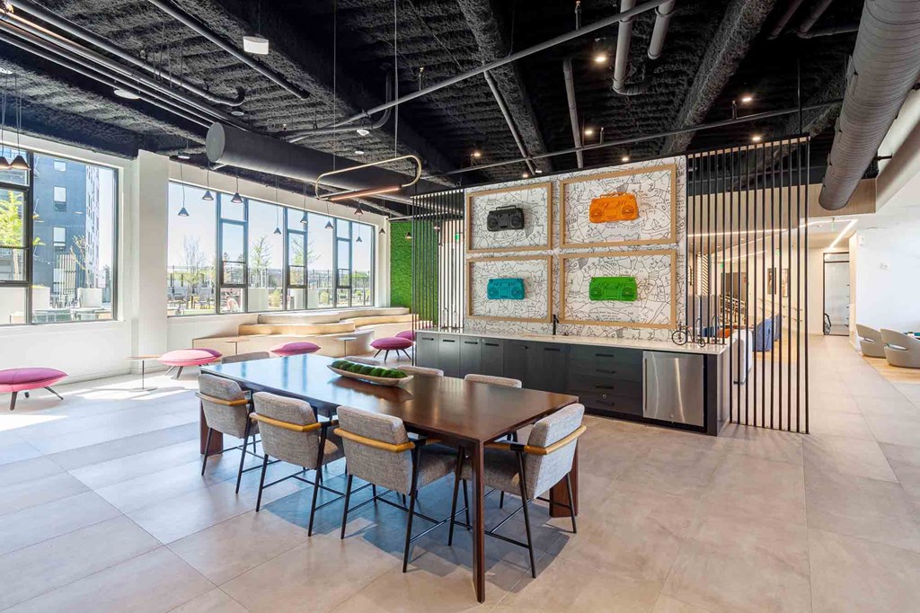 A modern dining room with a long table and chairs.