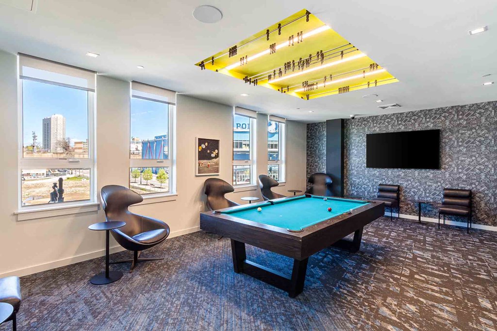 A room with a pool table and a chair.