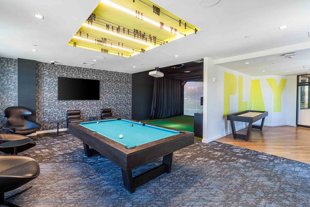 A room with a pool table and a television.