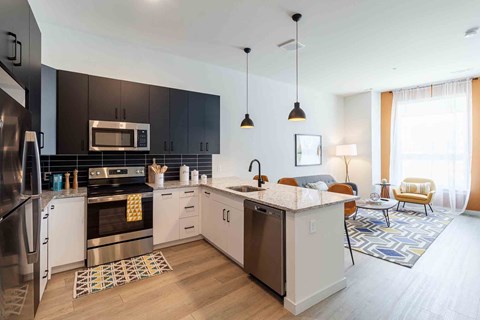 A modern kitchen with a refrigerator, oven, and sink.