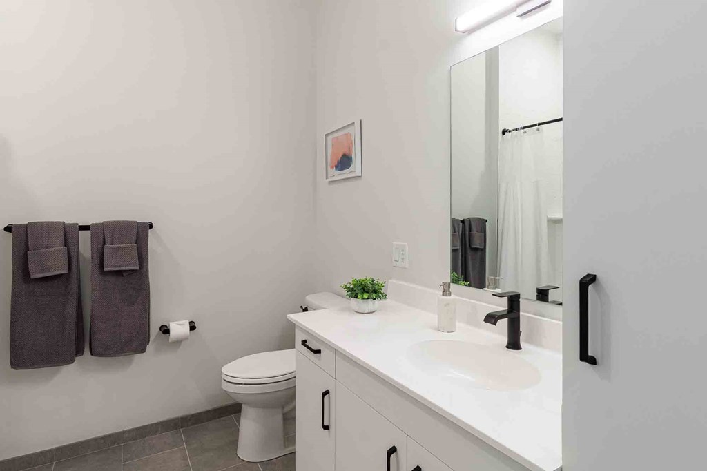A bathroom with a toilet, sink, and towel rack.