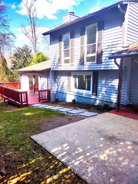 A blue house with a red fence and a small porch.