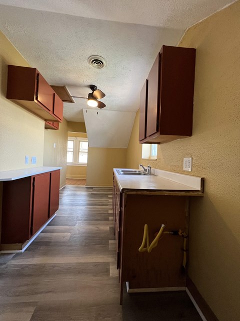 A kitchen with brown cabinets and a white counter top.