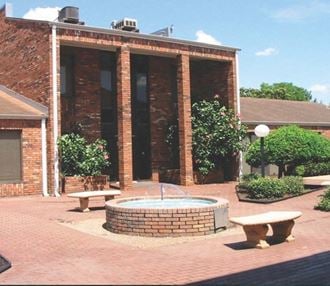 a fountain in front of a brick building