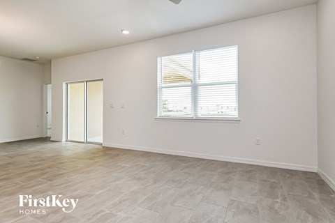 the living room of a new home with white walls and a window