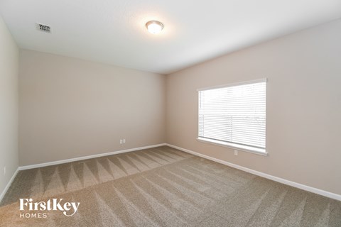 the spacious living room with carpet and a large window