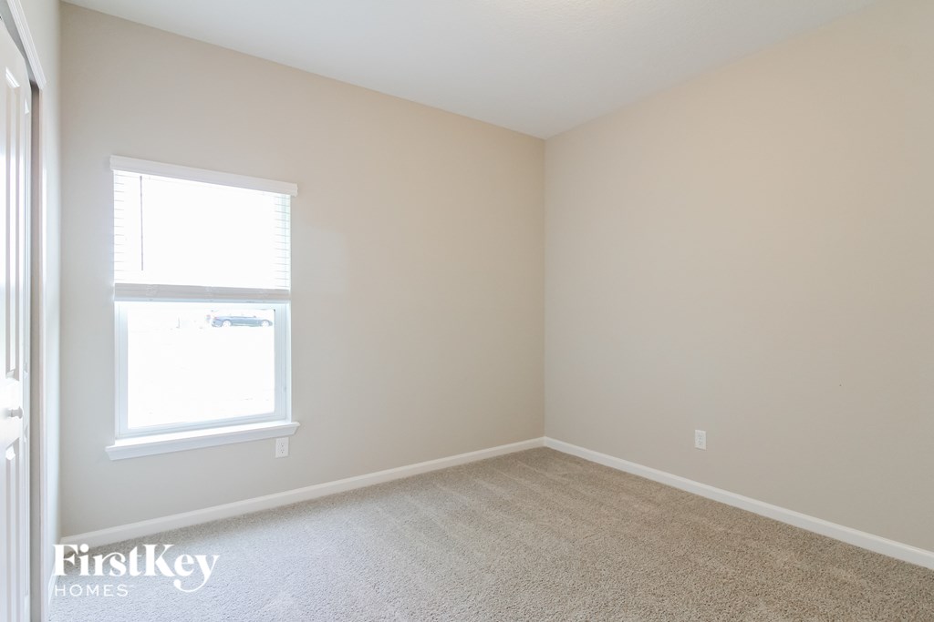 an empty room with a window and a carpet