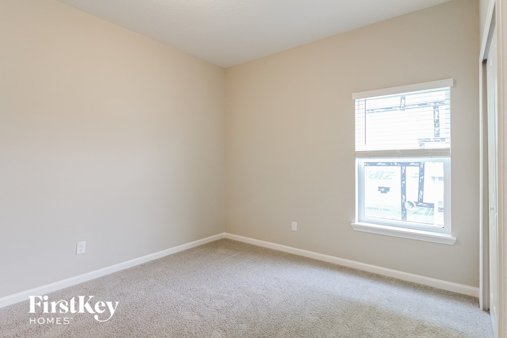 an empty room with a window and carpet