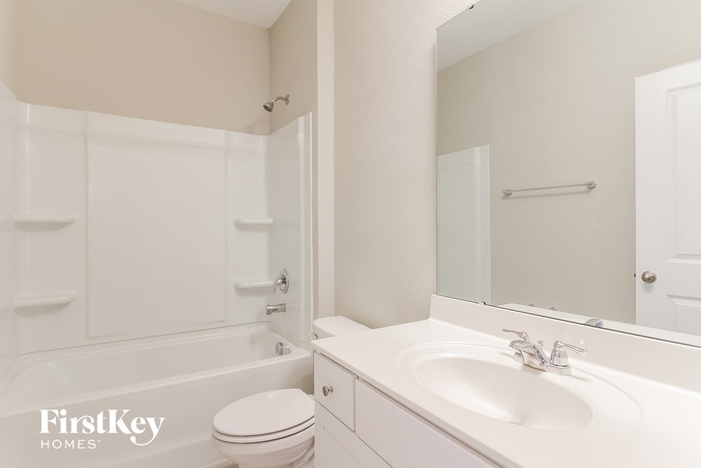 a bathroom with a sink and a toilet and a bath tub