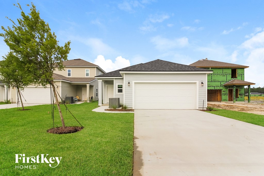 a home with a white garage door and a lawn