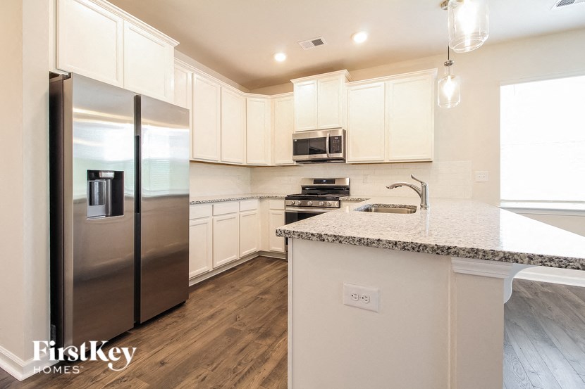 a kitchen with white cabinets and a stainless steel refrigerator