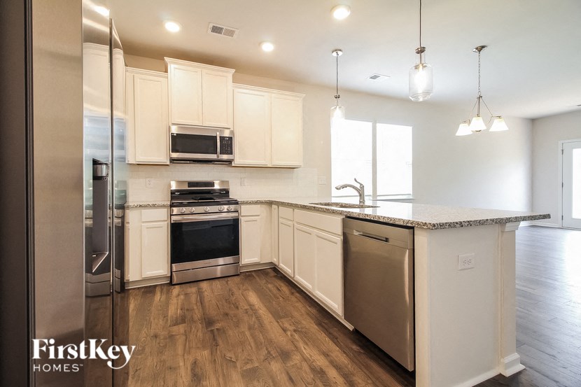a kitchen with white cabinets and stainless steel appliances