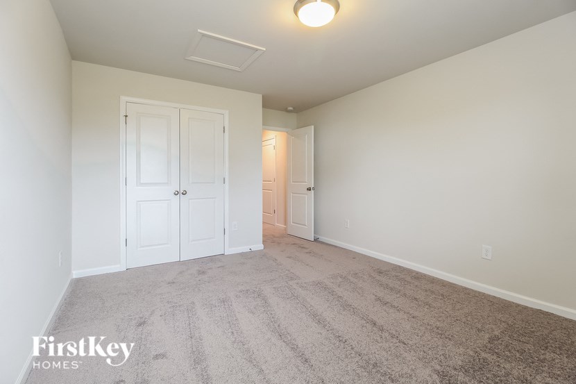 an empty living room with white doors and carpet