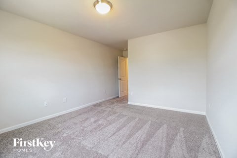 a spacious living room with carpet and white walls