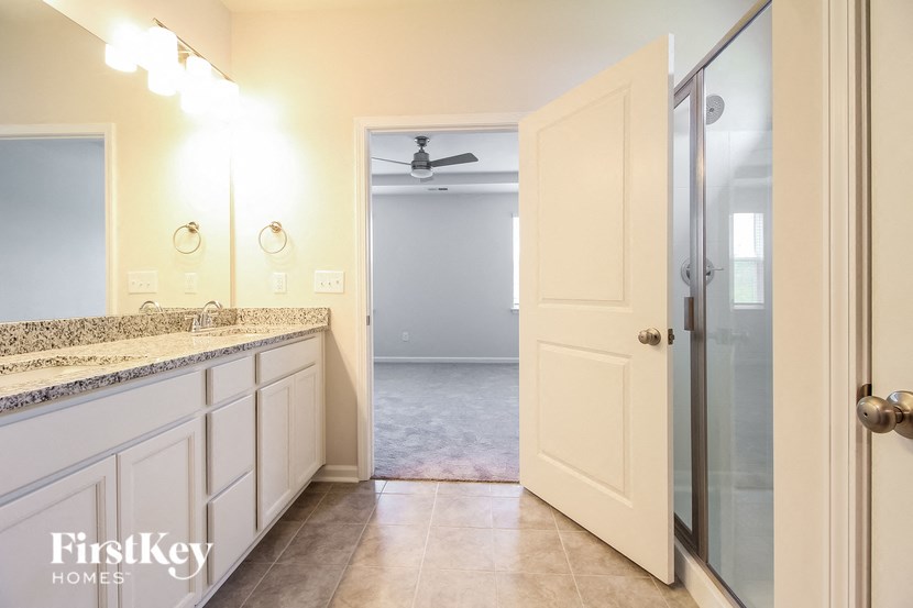 a bathroom with a shower and a sink and a mirror