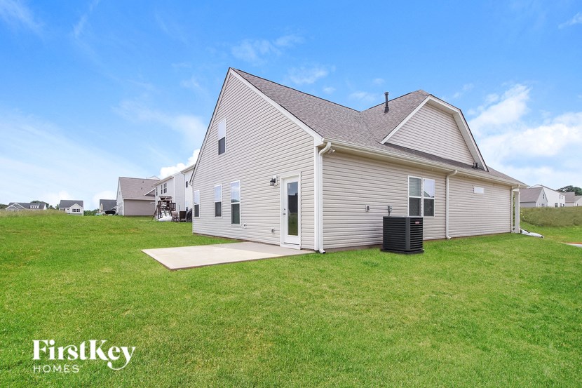 a small white house with a yard and a grassy field