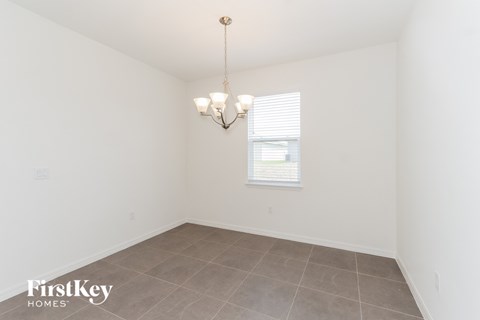 a dining room with a large window and a tiled floor