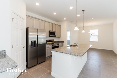 a large kitchen with stainless steel appliances and granite counter tops