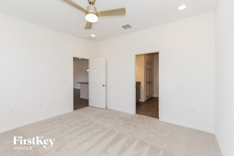 a living room with white walls and a ceiling fan