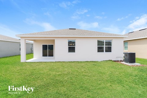 a white house with a grassy yard and a roof