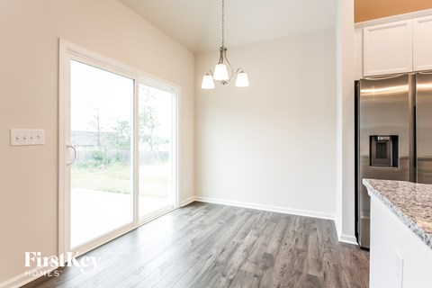 A kitchen area with a refrigerator, cabinets, and a countertop.