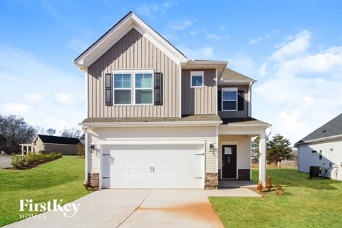 a beige and brown house with a white garage door