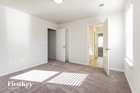 a master bedroom with carpeted flooring and white walls