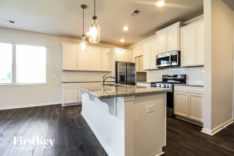 A kitchen with a granite countertop and white cabinets.