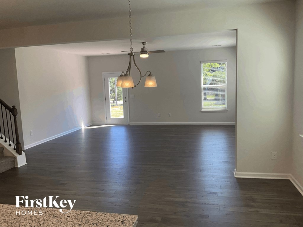 an empty living room with white walls and wood floors