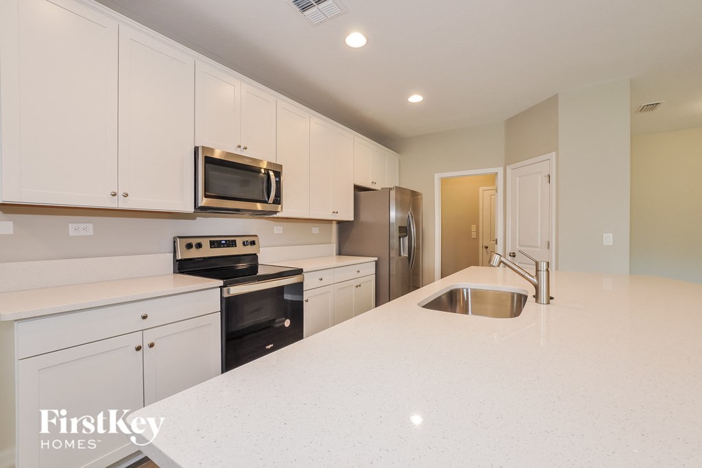 a kitchen with white cabinets and a white counter top
