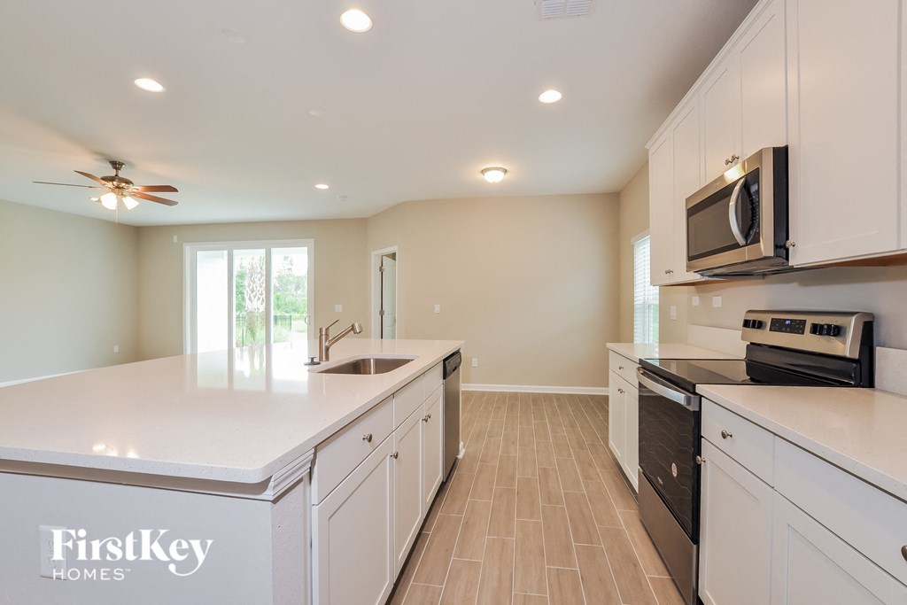 a large kitchen with white cabinets and a white counter top