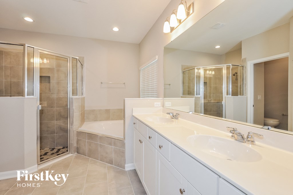 a white bathroom with two sinks and a shower and a tub