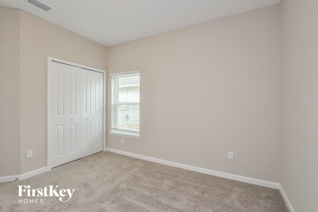 a bedroom with a carpeted floor and a white door
